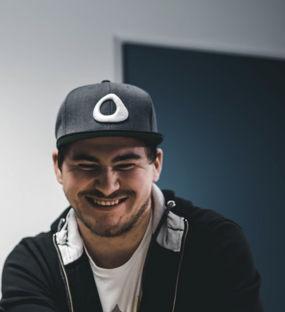 Julian Mazur, lächelnd, mit Cap und Kapuzenjacke